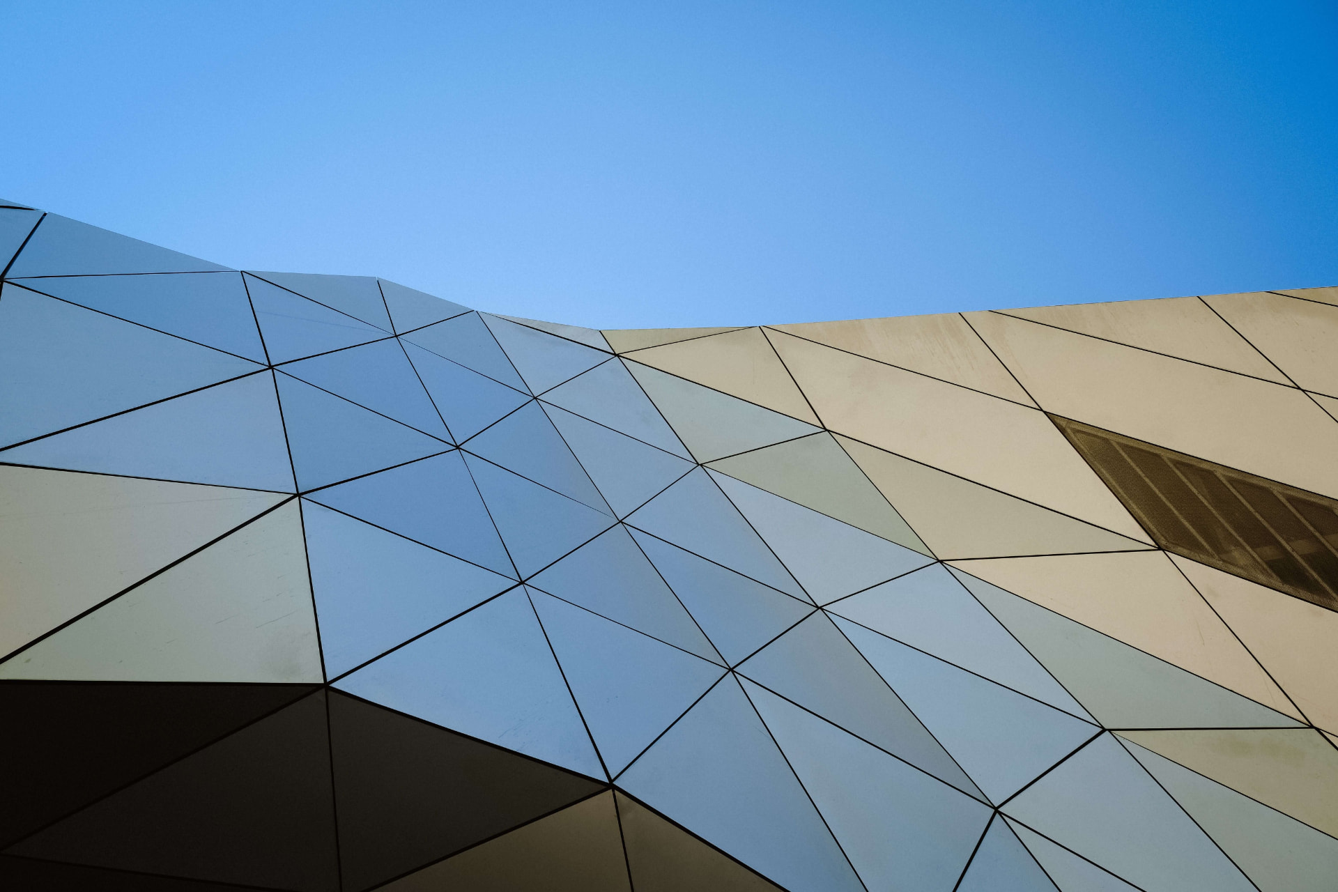 Angular architectural panels beneath a clear blue sky